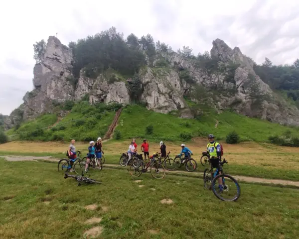 Grupa rowerzystów na tle skalnych ostańców. Jura Krakowsko-Częstochowska rowerem to wspaniała przygoda.