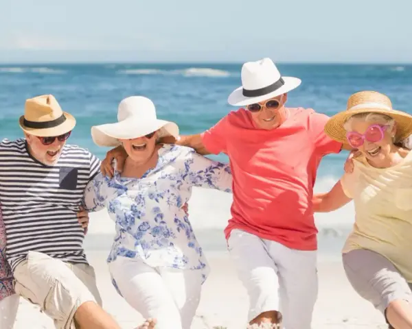 Szczęśliwi seniorzy na plaży, cieszący się słońcem i morzem. Idealne wczasy dla seniora 7 dniowe, pełne radości i wspólnych chwil.