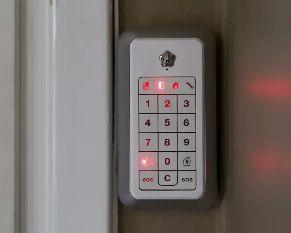 Verisure larma på med kod. En vit panel med siffror och symboler lyser rött.