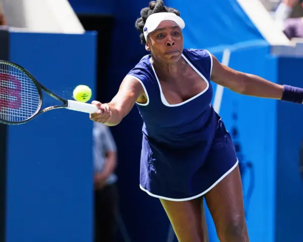 Venus Williams golpea la pelota en un partido, demostrando su destreza en los Grand Slams.