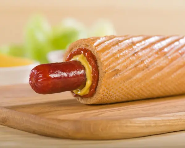 Pyszny hot dog francuski z musztardą i ketchupem, gotowy do zjedzenia.