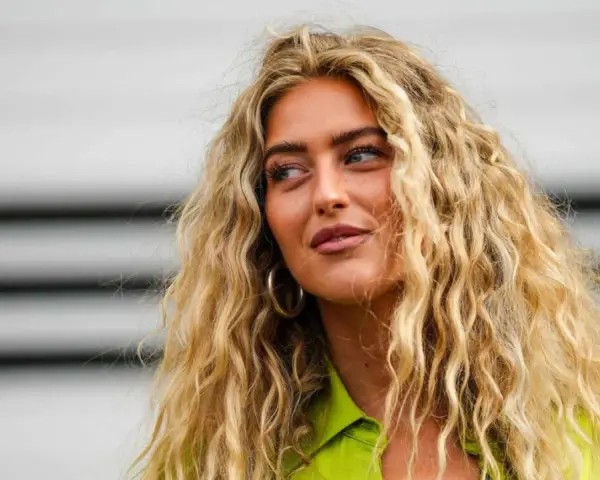 Frau mit voluminösen, blonden Locken, die zeigen, wie man Locken selber machen kann.