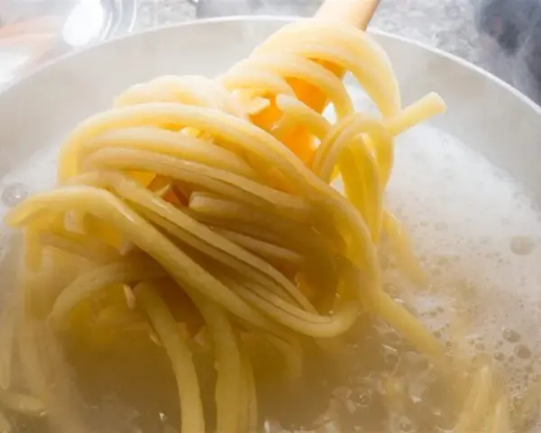 Jak ugotować makaron? Zobacz, jak spaghetti wrze w garnku, gotowe do podania.