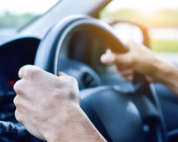 Dłoń trzyma smartfon z mapą i pinezką lokalizacji.