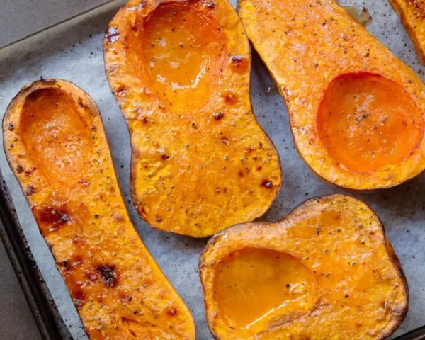Mitades de calabaza asada, doradas y jugosas, listas para convertirse en un delicioso puré de calabaza.