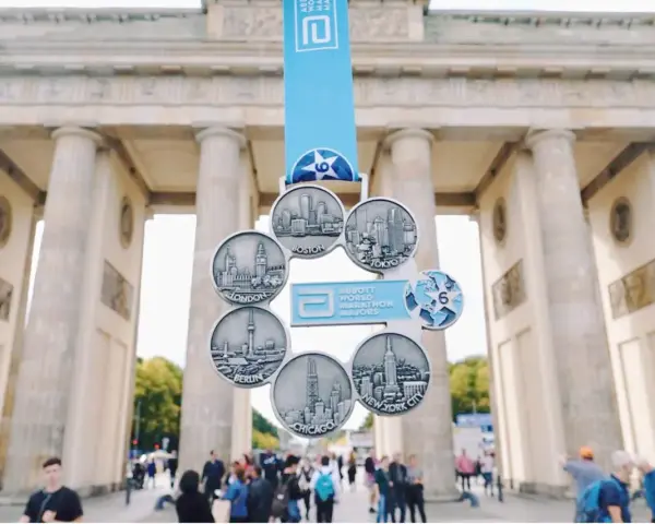 Medal za ukończenie korony maratonów świata z widokiem na Bramę Brandenburską.