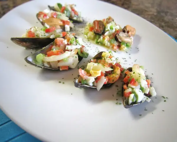 Mejillones a la vinagreta, una delicia fresca con tomate, cebolla y huevo picado.