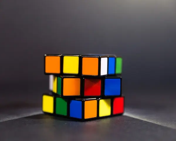 En färgglad speed cube ligger på ett mörkt underlag.