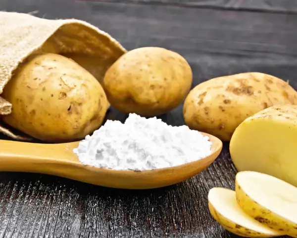 Kartoffeln und ein Löffel voller Kartoffelstärke, eine vielseitige kartoffelmehl alternative für Küche und Haushalt.