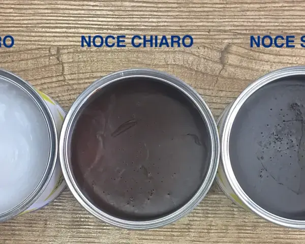 Tre barattoli di cera d'api per legno: neutra, noce chiaro e noce scuro, pronti per dare nuova vita ai tuoi mobili.