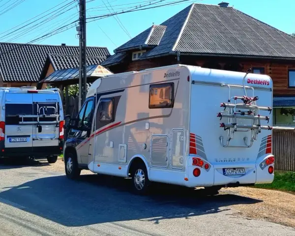 Dwa kampery zaparkowane na drodze w Rumunii, gotowe na przygodę.