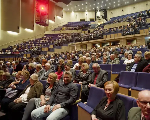 Widownia sali koncertowej, ludzie w eleganckich strojach, inspiracja: jak ubrać się na koncert muzyki filmowej.