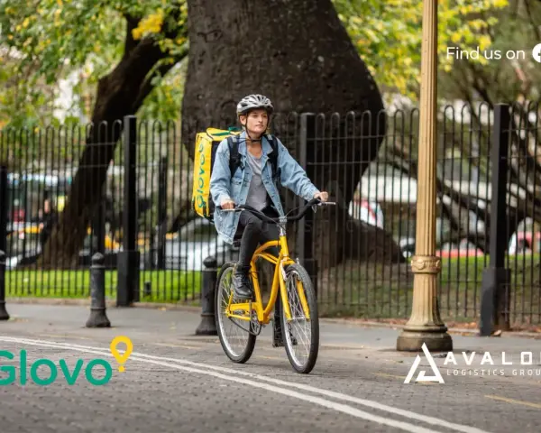 Kurier Glovo na rowerze z żółtą torbą. Dowiedz się, glovo co to jest - szybka dostawa jedzenia i nie tylko!