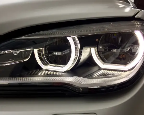 Nahaufnahme eines modernen Autoscheinwerfers mit leuchtendem Standlicht.