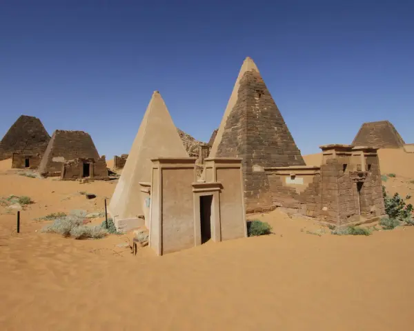 Niezwykłe piramidy w Meroe, fascynujące miejsca na sudan wycieczki. Piasek pustyni otacza starożytne budowle.