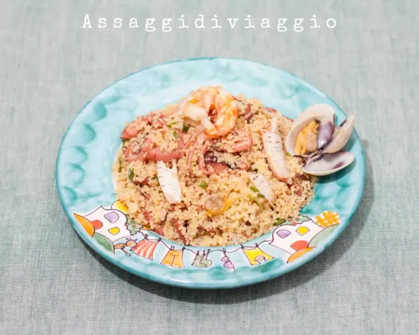 Un saporito cous cous di pesce con gamberi, polpo e cozze, servito su un piatto decorato.