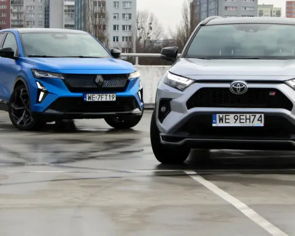 Niebieski i srebrny SUV, jedne z najlepszych aut, stoją na mokrym parkingu.