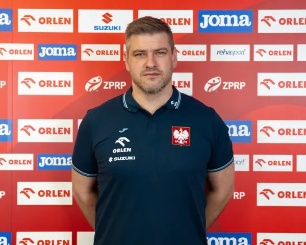 Mężczyzna w koszulce z orłem, podobny do Julena Aginagalde, stoi na tle ścianki z logotypami sponsorów, m.in. ORLEN.