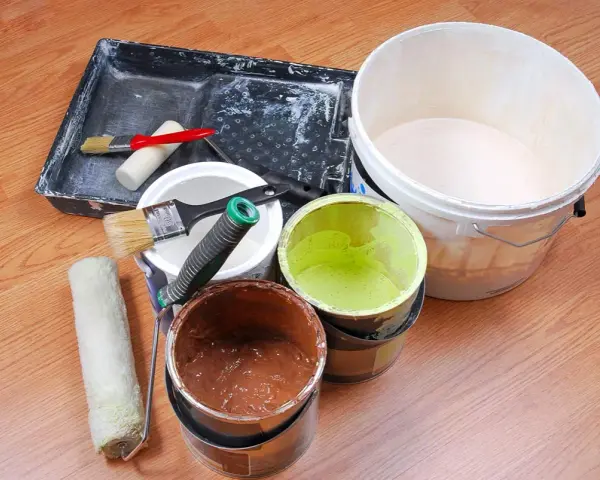 Attrezzi per pittura e barattoli di vernice avanzata, pronti per essere conservati.