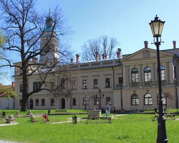 Zamek w Żywcu, z wieżą i dziedzińcem, otoczony zielenią i drzewami.