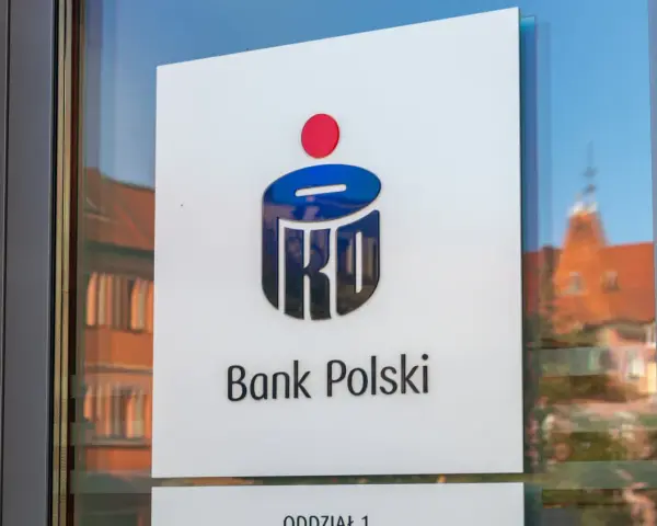 Logo PKO Bank Polski na drzwiach. W tle odbicie kamienicy.