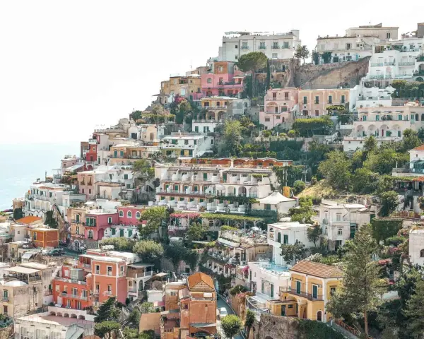 Colorful houses cascade down a hillside towards the sea, a picturesque scene perfect for any Europe itinerary.