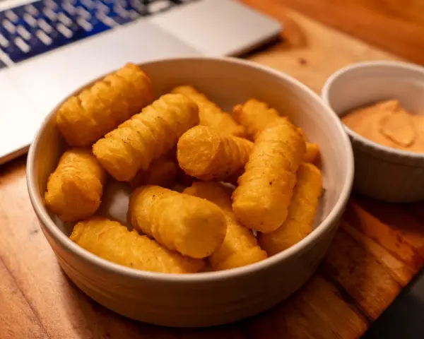 Goldbraune, knusprige Kroketten selber machen ist eine Kunst. Hier sind sie, bereit zum Dippen, neben einer Schüssel mit Sauce.