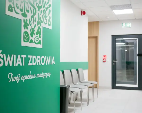 Nowoczesna poczekalnia kliniki medycznej z zieloną ścianą i napisem "Świat Zdrowia".