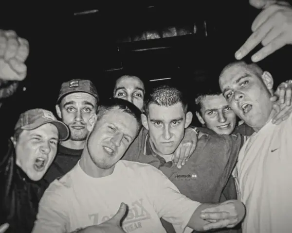 HZOP feat. Dudek RPK & RPS - każdy z nas. Grupa młodych mężczyzn pozuje do zdjęcia, jeden z nich pokazuje znak rock'n'rolla.