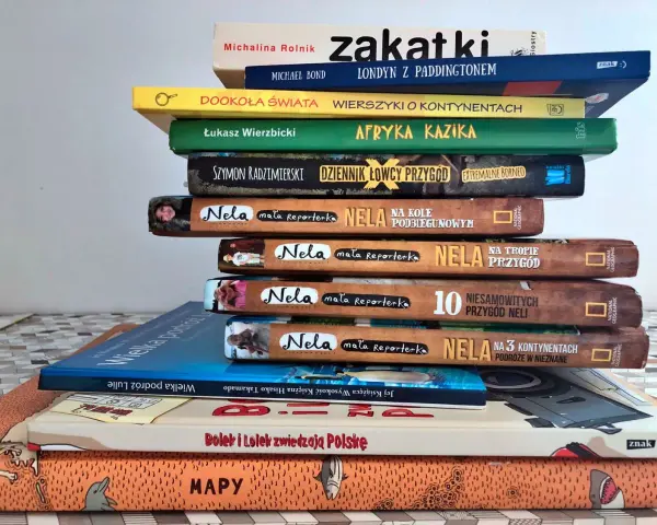 Stos książek podróżniczych top 10: "Afryka Kazika", "Dookoła świata", "Nela na 3 kontynentach" i inne.