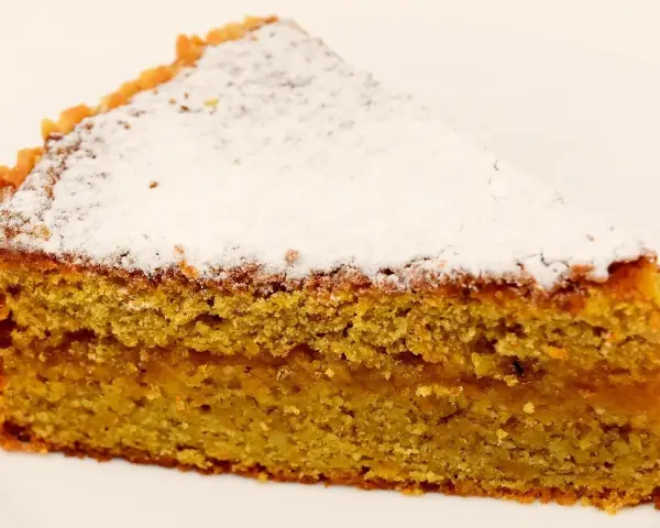 Wilgotne ciasto marchewkowe posypane cukrem pudrem. Idealne na deser, choć warto sprawdzić ciasto marchewkowe kcal przed zjedzeniem.