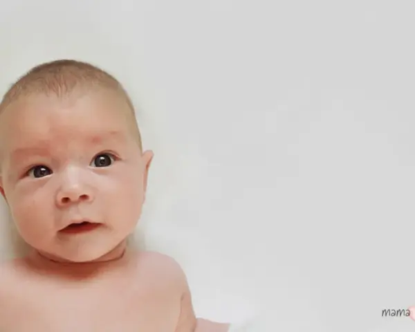Urocze niemowlę z zaciekawieniem patrzy w obiektyw. Może to początek drogi do pokonania kręcz szyi.