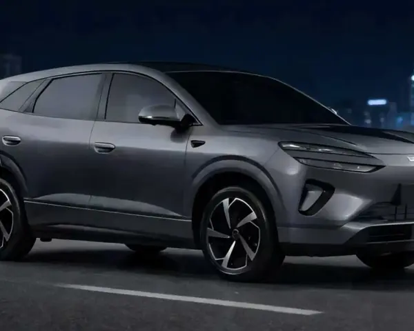 Szary samochód elektryczny BYD na tle nocnego miasta.