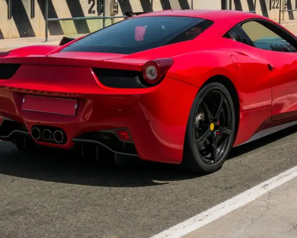 Czerwone Ferrari 458 Italia na torze wyścigowym, widok z tyłu.