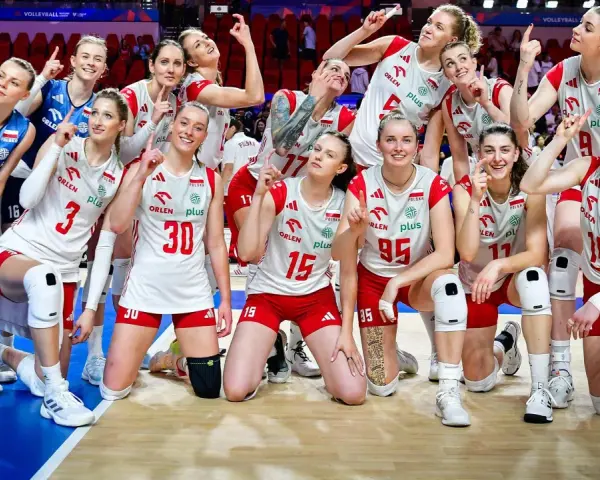 Siatkarki reprezentacji Polski w siatkówce, uśmiechnięte, pozują do zdjęcia, wskazując palcami w górę.