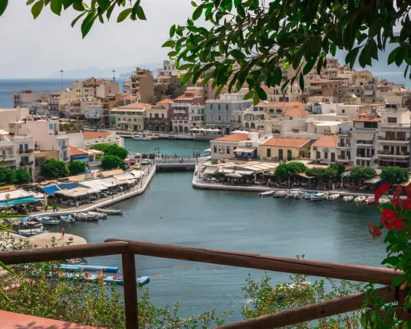 Malowniczy widok na port w Agios Nikolaos na Krecie. Woda lśni, a nadbrzeże tętni życiem.