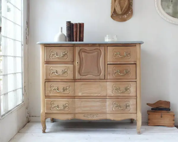 Muebles pintados a la tiza antes y después: cómoda de madera clara con tiradores dorados, lista para un nuevo look.