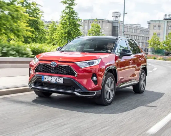 Czerwona Toyota RAV4 Hybrid na drodze miejskiej.