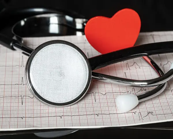 Stetoskop i czerwone serce na tle EKG.