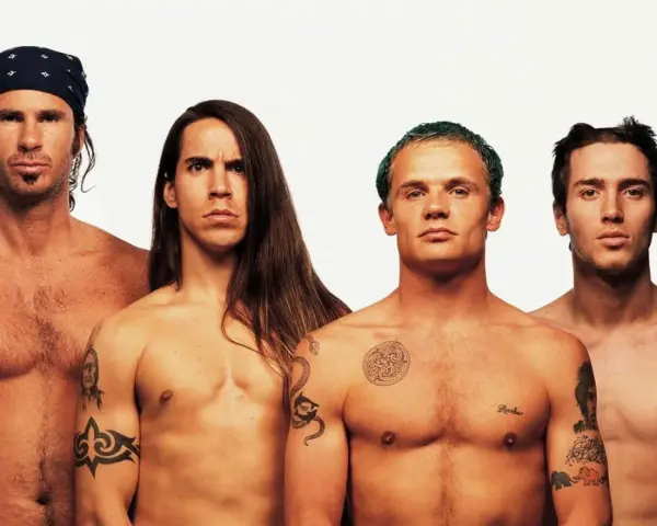 Les membres des Red Hot Chili Peppers, torse nu, posent pour une photo. L'âge ne semble pas avoir d'emprise sur leur énergie.