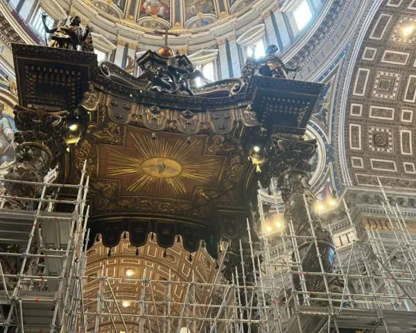 Wnętrze bazyliki z rusztowaniami wokół wspaniałego cyborium. Złoty dysk z gołębicą Ducha Świętego na suficie.