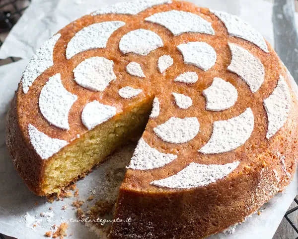 Deliziosa caprese al limone, soffice e profumata, con decorazione a fiore di zucchero a velo.