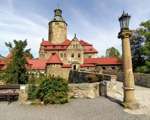 Zamek Czocha, gdzie jest? Ten malowniczy zamek z czerwonymi dachami i wieżą góruje nad okolicą, otoczony zielenią.