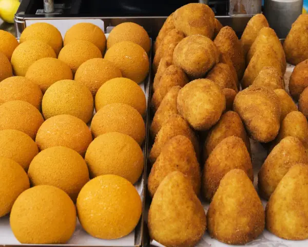 Arancini e arancine dorati, pronti per essere gustati. Un tripudio di sapori siciliani.