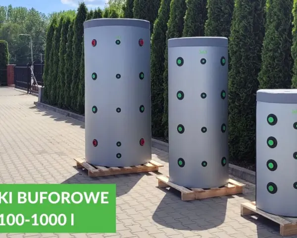 Trzy cylindryczne bufory 1000l wymiary, stojące na paletach przed żywopłotem. Zielone i czerwone kółka na szarych zbiornikach.