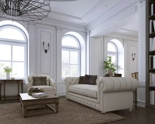 Elegancki salon z sofą, fotelem i książkami na półce.