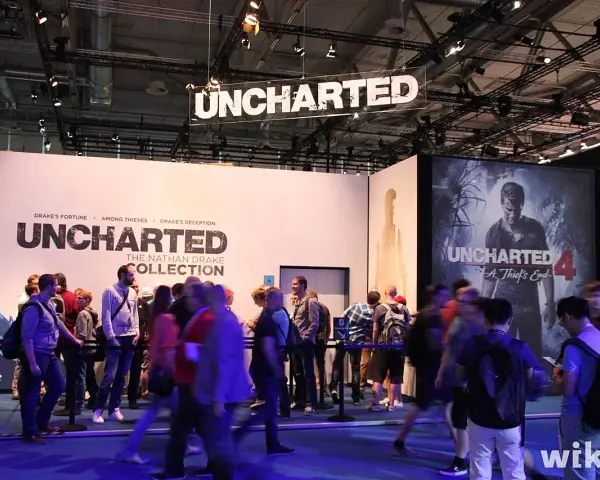 Gente en un evento de videojuegos, con carteles de Uncharted 4 y The Nathan Drake Collection. Se ven varios capítulos de Uncharted.