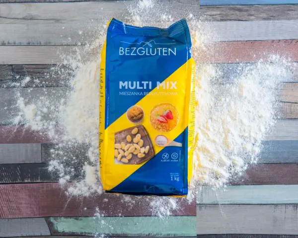 Opakowanie mąki Bezgluten Multi Mix, rozsypana mąka na drewnianym tle. To najzdrowsza mąka bezglutenowa do Twoich wypieków.
