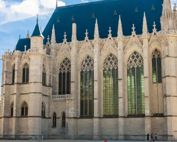 The stunning Sainte-Chapelle in Paris, with its Gothic architecture and vibrant stained-glass windows, stands majestically under a bright blue sky.