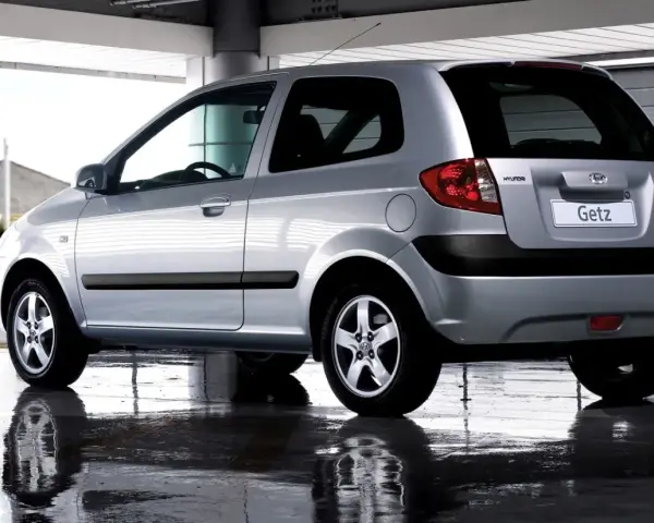 Srebrny Hyundai Getz 1.1 z czarnymi listwami, odbijający się w mokrej nawierzchni pod zadaszeniem.